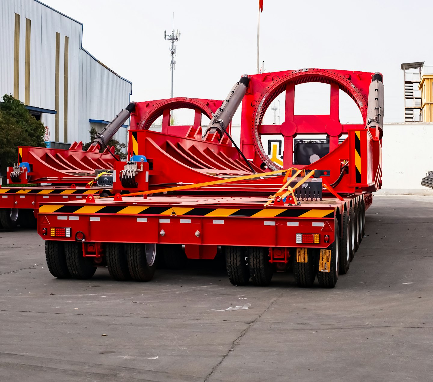 Two red industrial trailers parked on a paved lot.