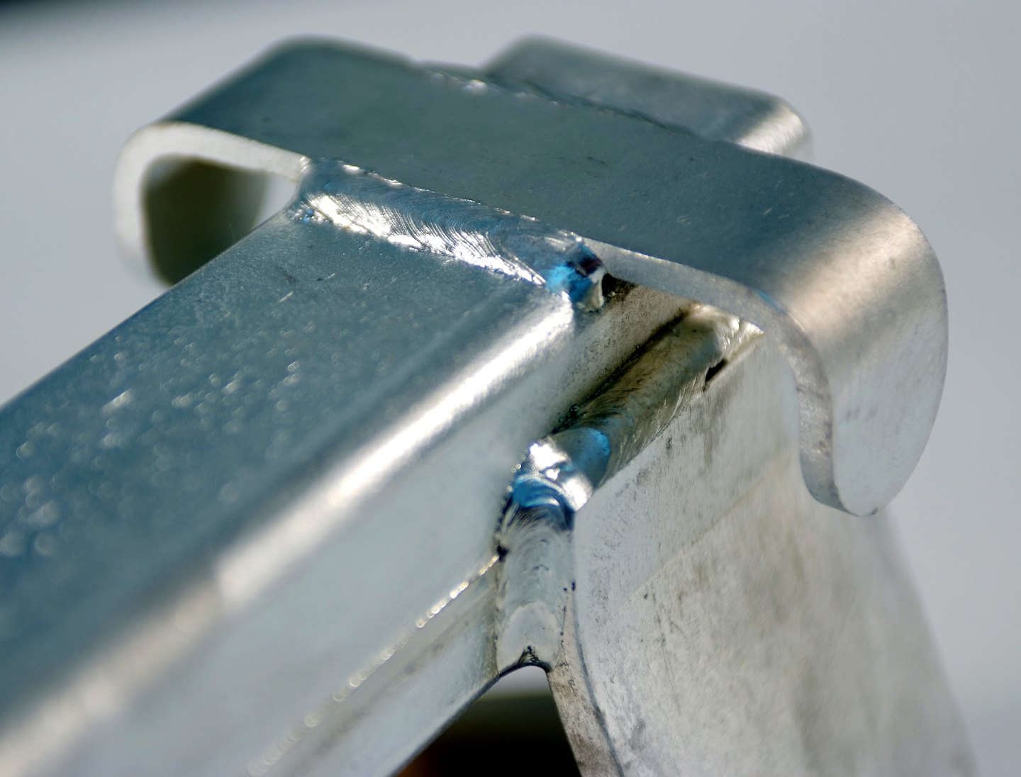 Aluminum welding joining silver metal components with visible weld beads.